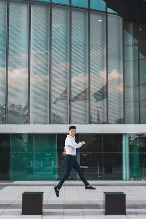 Man jumping on pavement of highrise