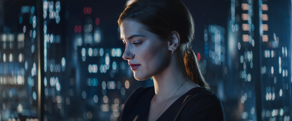 Portrait of Young Successful Businesswoman Sitting at Desk Working on Laptop Computer in City Office Late At Night.