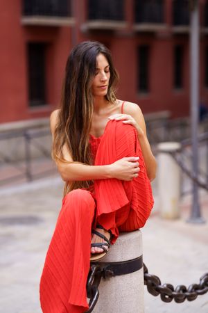An Elegant Woman Dressed in a Stunning Red Dress Posing Gracefully Outdoors in Nature