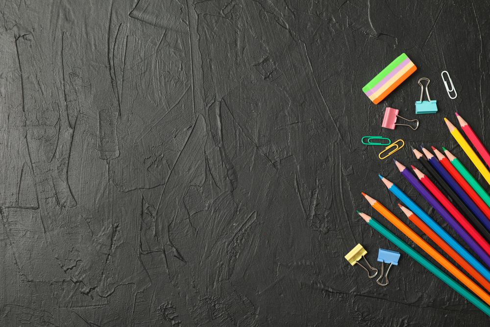 Composition with school supplies on dark background, space for text