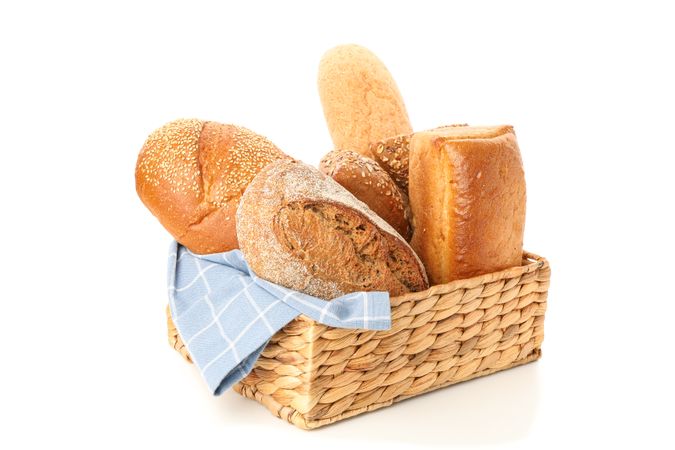 Bakery products in straw basket isolated on blank background