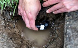 Sprinkler repair with male hands holding valve