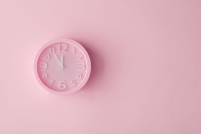 Pastel pink clock on pink painted wall
