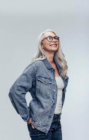 Woman wearing eyeglasses with hands in jean pockets