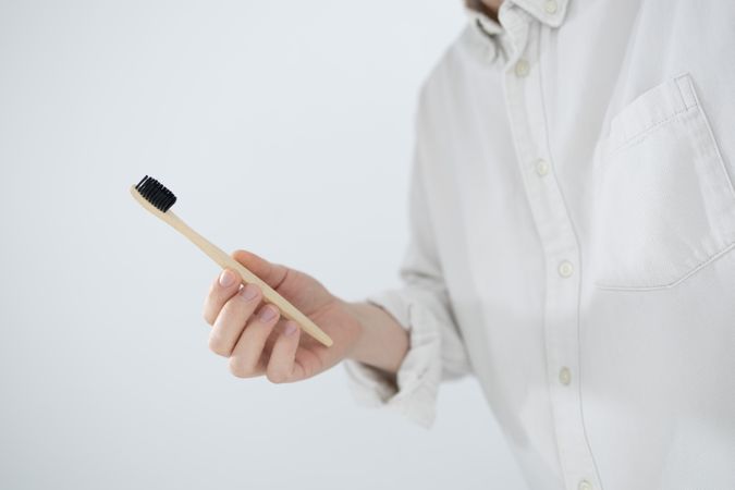 Man holding bamboo toothbrush