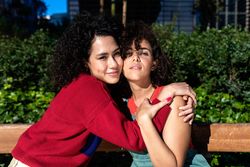 Female couple in love holding each other in city park