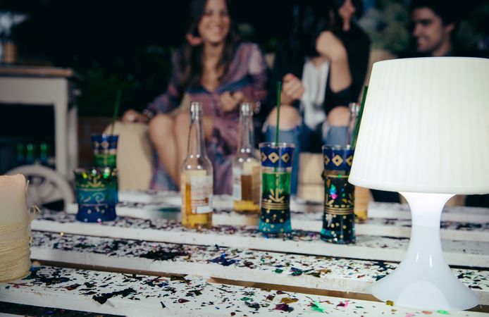 Lamp over pallets table with confetti in outdoors party