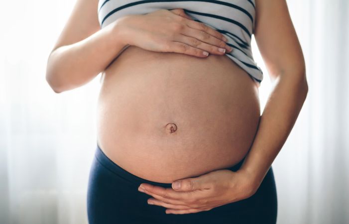 Pregnant woman holding her tummy