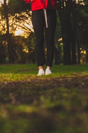 Crop sportive woman standing on meadow