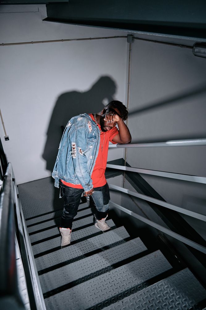 Stylish Black man leaning on metal railing