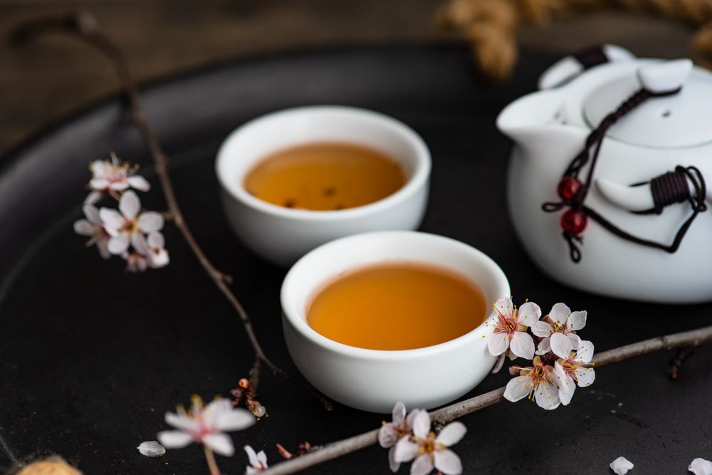 Cups of tea and tea pot with floral decor