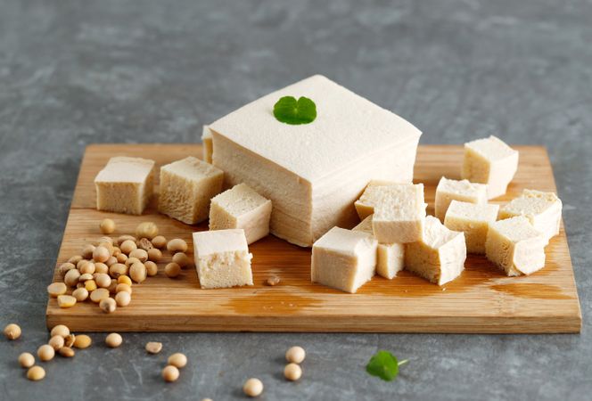 Tofu cut on breadboard with soybeans