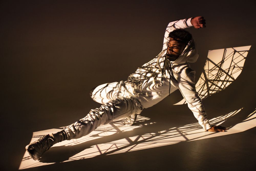 Black man dancing under bright light