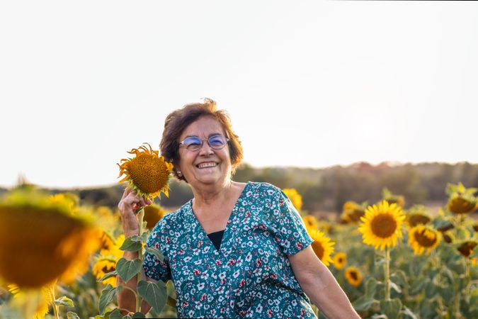 Older woman in a field of sunflowers