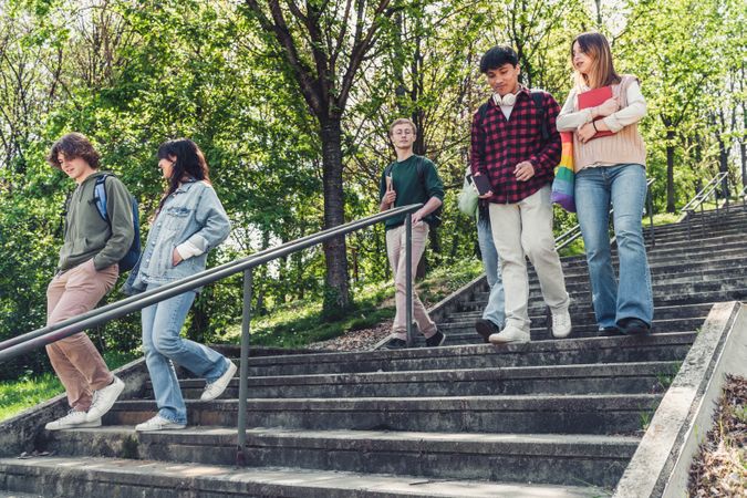Multi-ethnic group of students walking down stairs outside