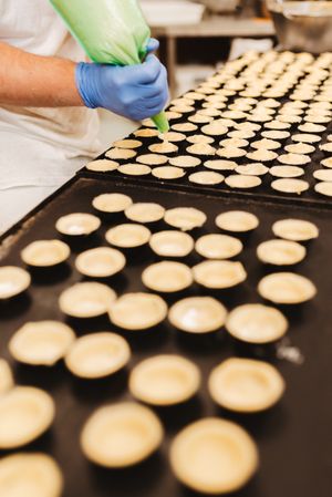 Crop baker squeezing dough on tray