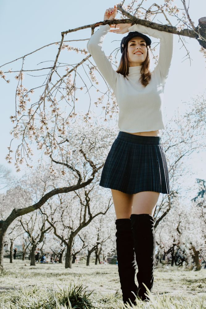 Young happy woman between trees in garden