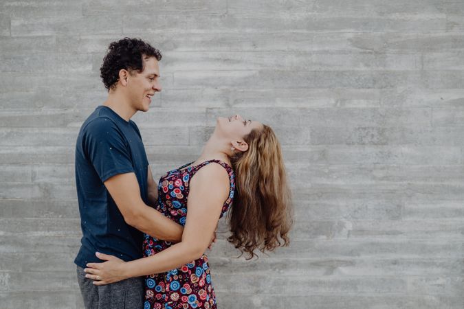 man and woman hugging at nearby street wall