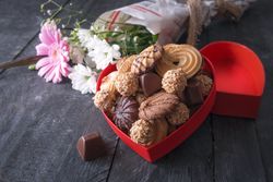 Red box full of sweets and flowers for Valentine’s Day concept