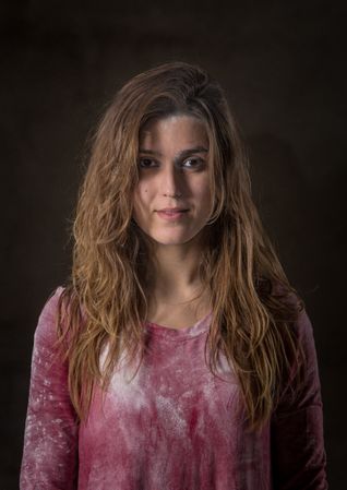 Young woman looking at camera in darkness
