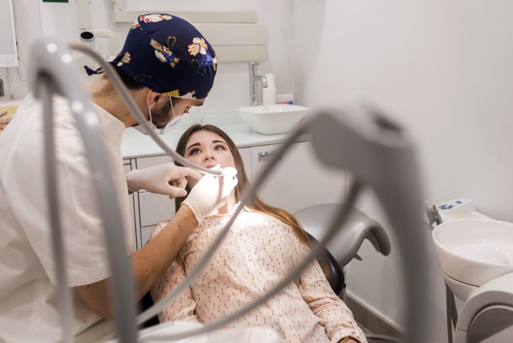 Male dentist working on mouth of teenage patient