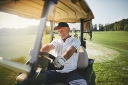 Man driving golf cart on court