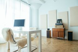 Office room with desk and monitor, vintage stereo and large bright windows