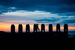 Silhouette of person between stone sculptures in sunset