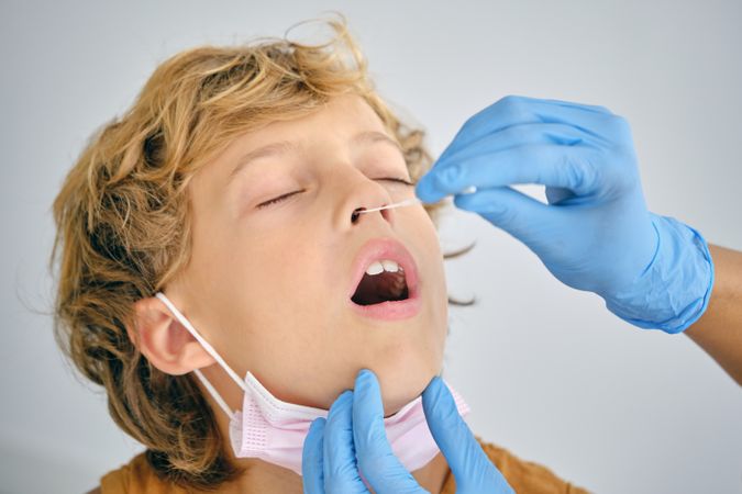 Crop medic taking coronavirus test from boy in hospital