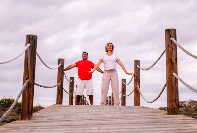 Couple practicing martial arts on lumber path