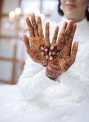 Woman hands with heart shaped henna tattoo