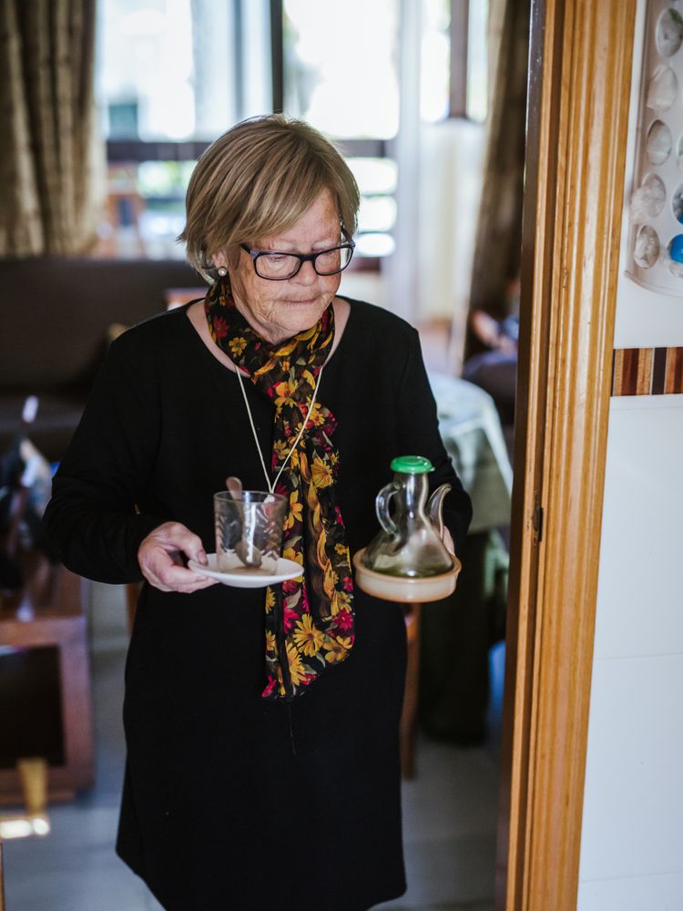 Mature woman carrying glassware