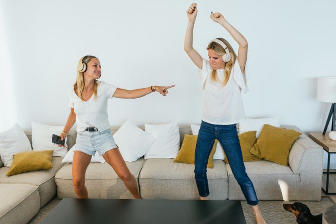 Cheerful women dancing while listening to music