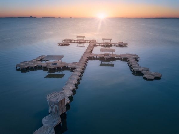 Overwater pier of resort at sunset