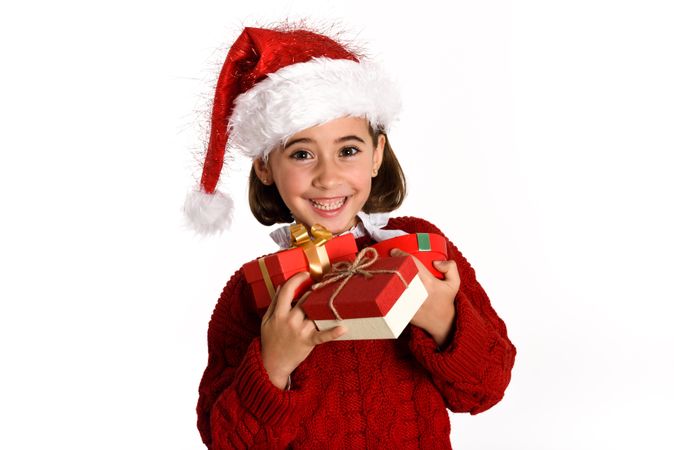 Smiling girl in red Santa outfit holding a present box