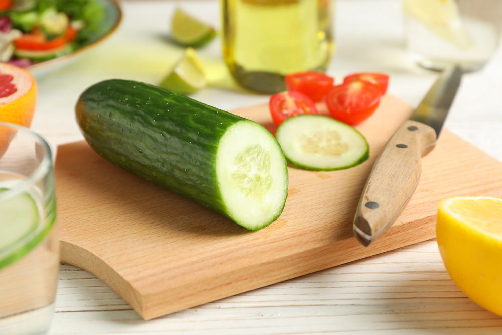 Ingredients for salad, kitchen supplies and oil on wooden background, close up