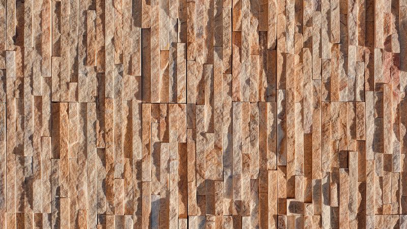 Textured sandstone brick wall with natural orange and beige tones