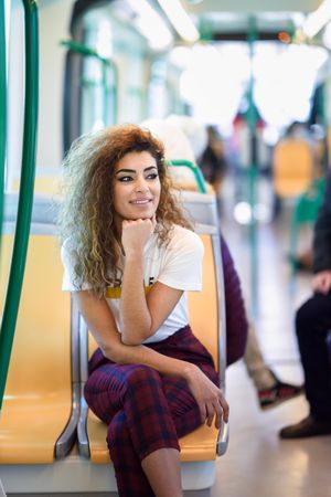 Arab woman sitting in train carriage looking around