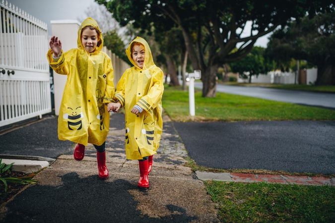 Twin sisters walking outdoors in waterproof coats