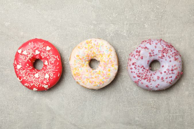 Tasty donuts on gray background, top view