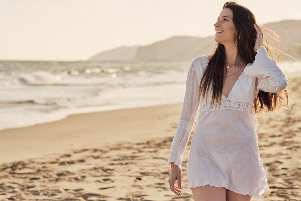 Young woman at the beach at sunset