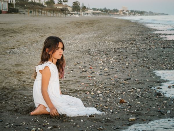 girl sitting on beach in daylight