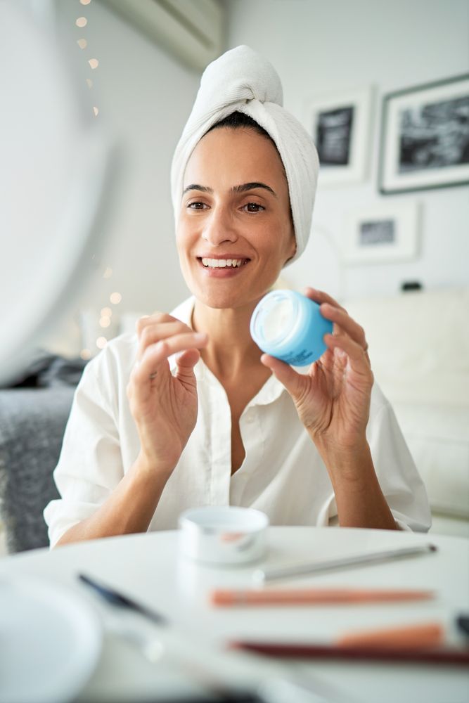 Happy woman with facial cream in morning time