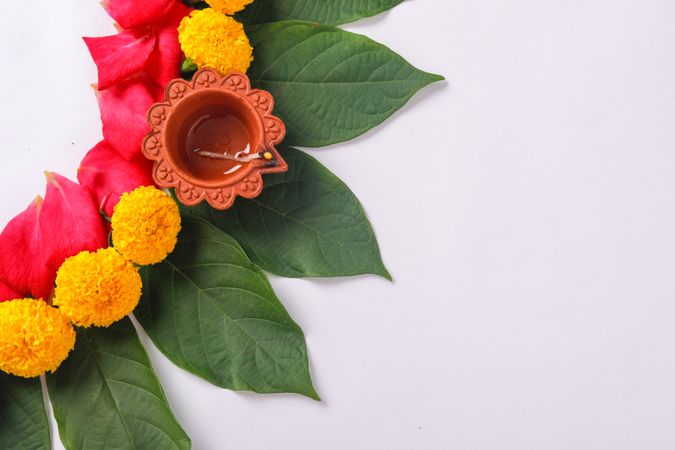 Top view of saffron flowers and diya on light background