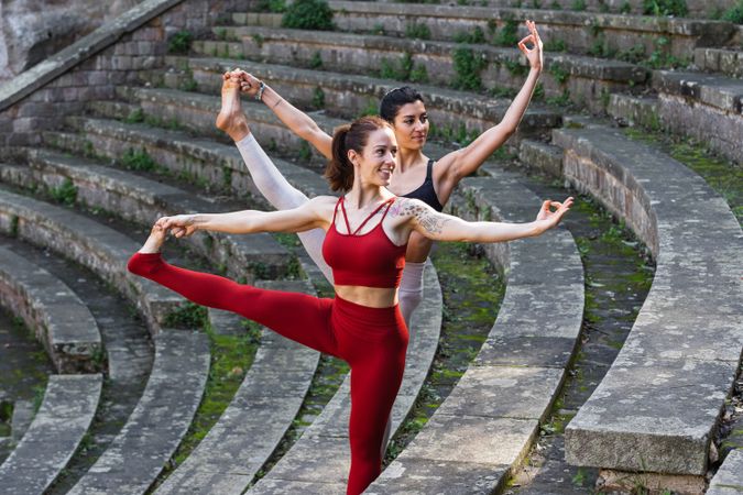 Content women doing yoga in Extended Standing Hand to Toe pose