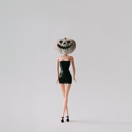 Doll in dress with pumpkin skull head