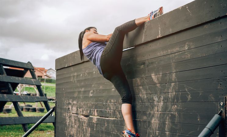 Participant in obstacle course climbing wall