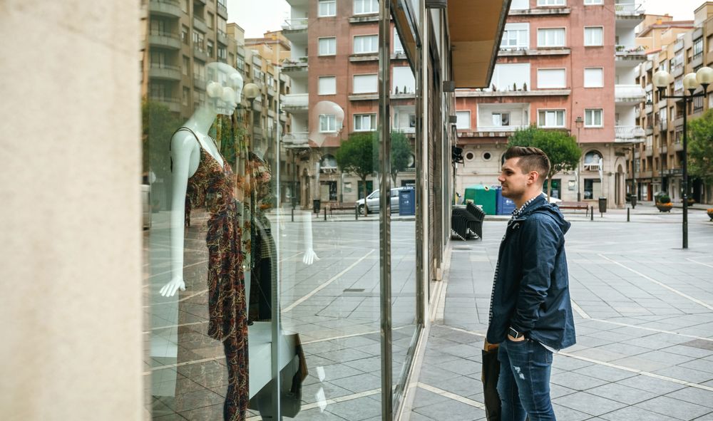 Man looking shop window to buy a gift