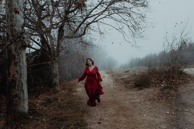 Woman in red dress walking in foggy area