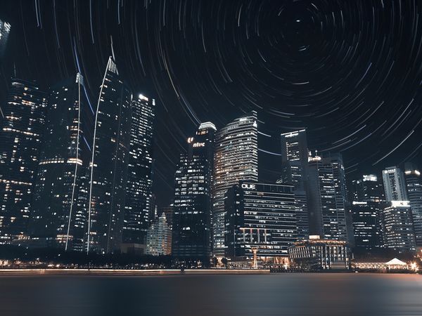 Star trail in sky over city skyline during night time